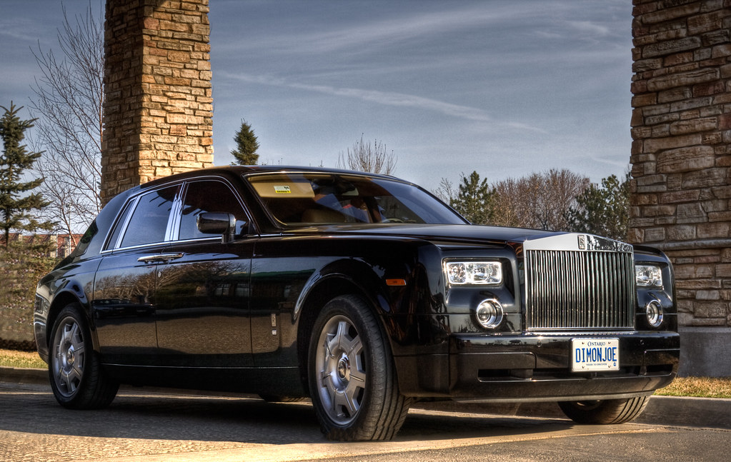 The same black luxury sedan with mirror-gloss paint after a full exterior detail