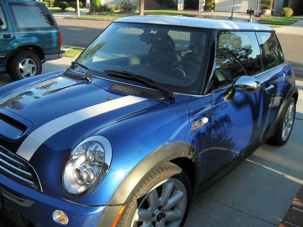 The same blue car gleaming with glossy paint after a professional hand wash